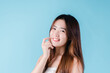 © Kiattisak - Charming portrait of Asian woman smiling confidence beauty make up on the blue background