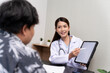 © SKW - A beautiful Asian doctor discusses the condition of a male patient being hospitalized Check  results  in tablet