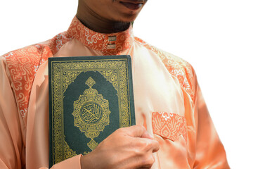 Wall Mural - Religious muslim man holding holy quran book in hands.concept for Ramadan, Eid al Fitr, eid ad-ha, meditation, islamic praying, Arabic on the text translated with Quran