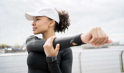 Wall Mural - A female athlete is running, doing an active workout on the street. Uses the fitness watch app on his arm