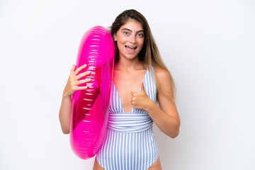 Young woman in swimsuit holding an air mattress donut isolated on white background with thumbs up because something good has happened