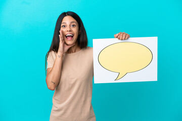 Wall Mural - Young woman over isolated background holding a placard with speech bubble icon and shouting