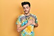 © Krakenimages.com - Young hispanic man wearing casual clothes smiling with hands on chest with closed eyes and grateful gesture on face. health concept.