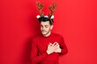 © Krakenimages.com - Young hispanic man wearing cute christmas reindeer horns smiling with hands on chest with closed eyes and grateful gesture on face. health concept.