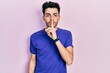 © Krakenimages.com - Young hispanic man wearing casual t shirt asking to be quiet with finger on lips. silence and secret concept.