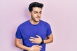 © Krakenimages.com - Young hispanic man wearing casual t shirt with hand on stomach because indigestion, painful illness feeling unwell. ache concept.