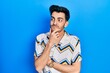 © Krakenimages.com - Young hispanic man wearing casual clothes thinking worried about a question, concerned and nervous with hand on chin