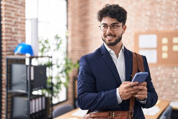 Wall Mural - Young hispanic man business worker using smartphone at office