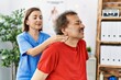 © Krakenimages.com - Middle age man and woman wearing physiotherapy uniform having rehab session massaging neck at physiotherapy clinic