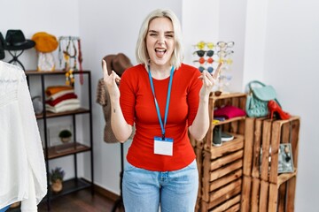 Sticker - Young caucasian woman working as manager at retail boutique shouting with crazy expression doing rock symbol with hands up. music star. heavy concept.