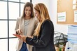 © Krakenimages.com - Mother and daughter business workers smiling confident using touchpad at office