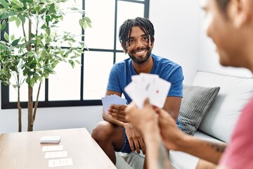 Poster - Two men friends playing poker cards sitting on sofa at home