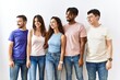 © Krakenimages.com - Group of young people standing together over isolated background looking away to side with smile on face, natural expression. laughing confident.