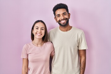 Sticker - Young hispanic couple together over pink background with a happy and cool smile on face. lucky person.