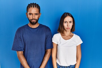 Poster - Young hispanic couple standing together skeptic and nervous, frowning upset because of problem. negative person.