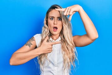 Sticker - Beautiful young blonde woman doing picture frame gesture with hands afraid and shocked with surprise and amazed expression, fear and excited face.