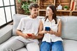 © Krakenimages.com - Man and woman couple smiling confident using smartphone at home