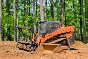 A construction industrial grader carries out the process of leveling the land in preparation for construction new building on the site