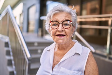 Senior grey-haired woman smiling confident standing at street