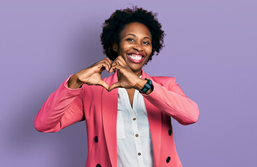 Canvas Print - African american woman with afro hair wearing business jacket smiling in love doing heart symbol shape with hands. romantic concept.