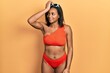 © Krakenimages.com - Young african american girl wearing bikini smiling confident touching hair with hand up gesture, posing attractive and fashionable