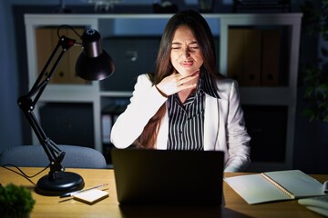 Sticker - Young brunette woman working at the office at night with laptop cutting throat with hand as knife, threaten aggression with furious violence