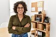 Young hispanic woman smiling confident standing with arms crossed gesture at office