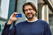 © Krakenimages.com - Middle age handsome man holding credit card at the town