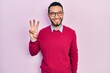 © Krakenimages.com - Hispanic man with beard wearing business shirt and glasses showing and pointing up with fingers number three while smiling confident and happy.
