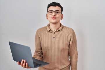 Wall Mural - Non binary person using computer laptop looking at the camera blowing a kiss on air being lovely and sexy. love expression.