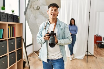 Sticker - Beautiful model smiling happy posing at photography studio. Professional photographer man standing and holding camera.