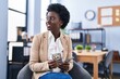 © Krakenimages.com - Young african american woman business worker counting dollars sitting on chair at office