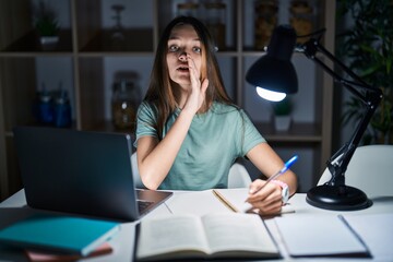 Canvas Print - Teenager girl doing homework at home late at night hand on mouth telling secret rumor, whispering malicious talk conversation