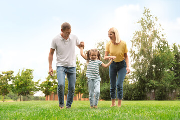 Sticker - Cute little girl having fun with her parents in park on summer day