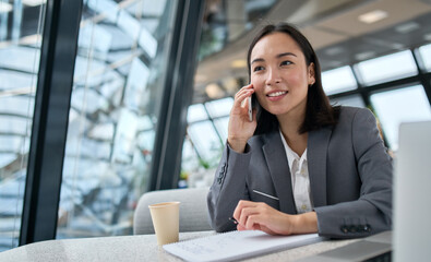 young busy chinese business woman talking on phone working in modern office. asian businesswoman com