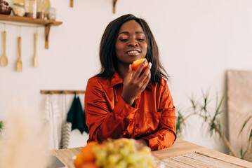 Wall Mural - Beautiful young woman eating yogurt in the kitchen in the morning. Healthy food. Close up. Portrait shot