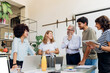 © Westend61 - Smiling business colleagues discussing with each other in office