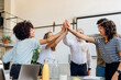 © Westend61 - Cheerful business colleagues giving high-five to each other at office