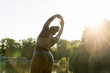 © gpointstudio - Plus sized African American woman stretching at the park in a  summer day