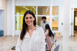© Westend61 - Portrait of smiling businesswoman in office with colleagues in background