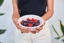 Hands Of Woman Holding Bowl Of Fresh Berries