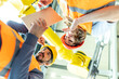© Westend61 - Male and female colleagues discussing robotic machine in industrial factory, low angle view