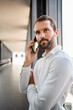 © Westend61 - Young businessman talking on smart phone standing at elevated walkway