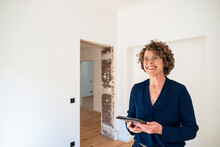 Happy Real Estate Agent With Tablet PC At New Home
