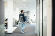 © Westend61 - Businessman with solar panel walking at workplace
