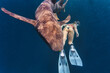 © Westend61 - Woman swimming by nurse shark in deep sea