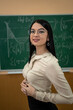 © RomanR - portrait of female student in the classroom near blackboard