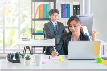 Asian. Female Operator is answering the phone for customer service sale and business consultant in a support office.