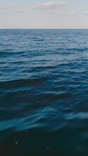 vertical video of blue tranquil sea with waves and skyline