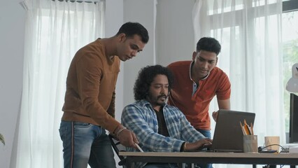 Wall Mural - medium slowmo of team of male indian software developers discussing programming while looking at lap